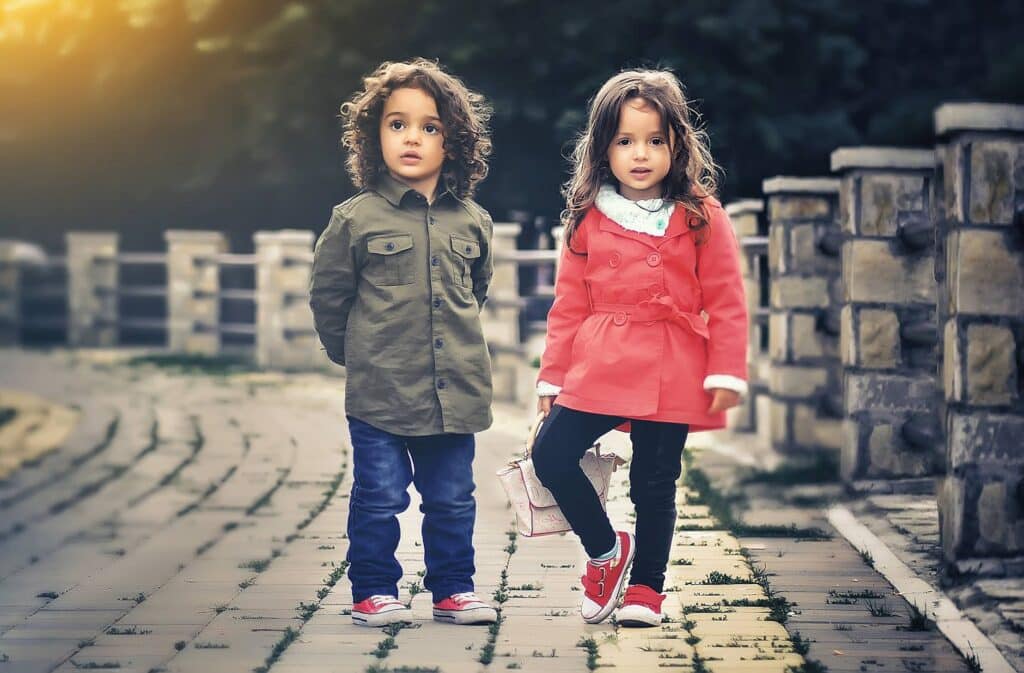 Two Kids a girl and a boy standing with each other wearing walking shoes for kids with high arch feet
